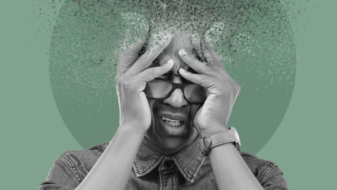 Hombre sujetando su cabeza por estrés y agobio